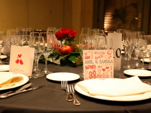 Mesa de allegados con manzanas y rosas rojas como centro de mesa